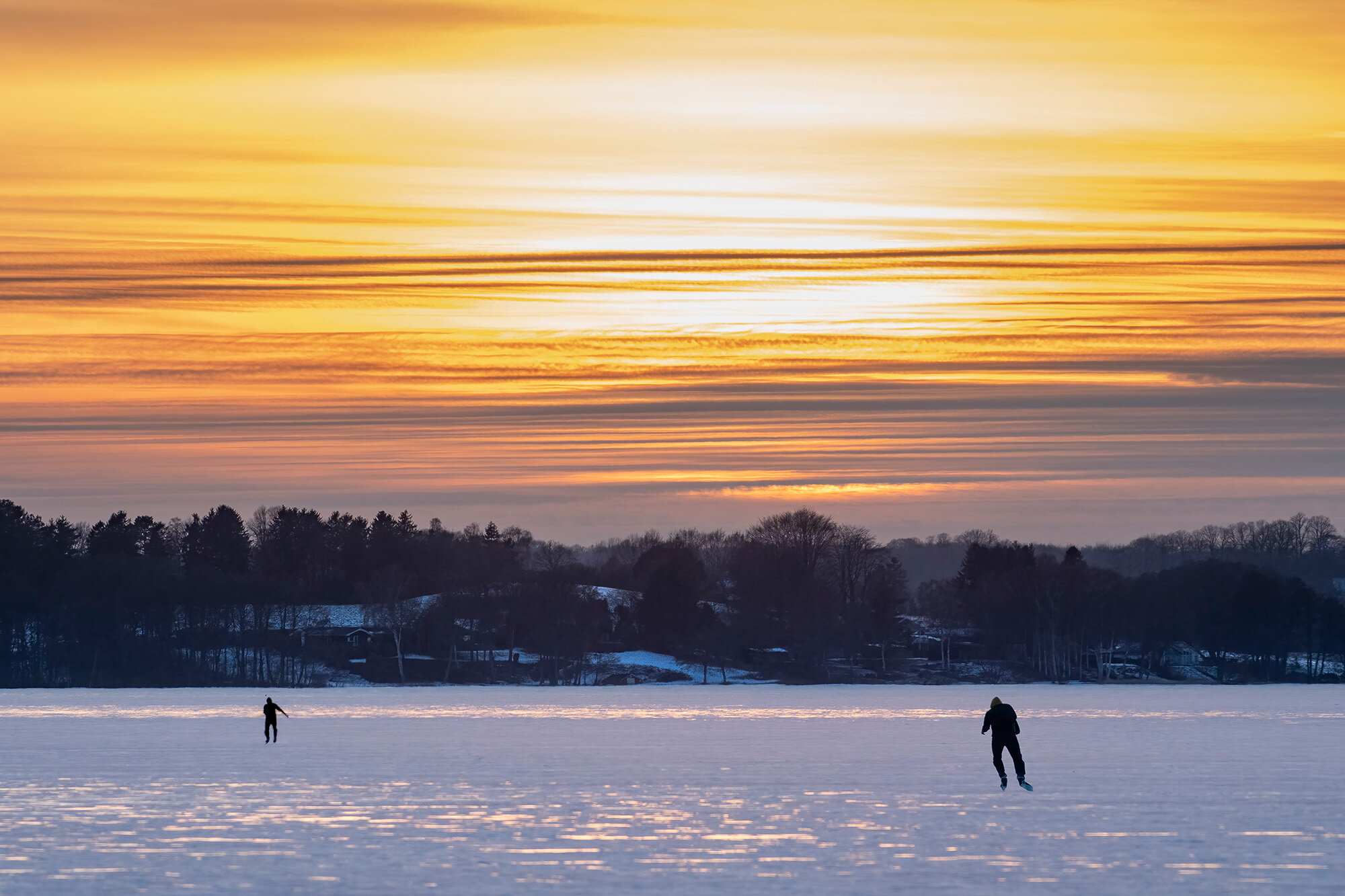 Skøjteløbere i solnedgangen